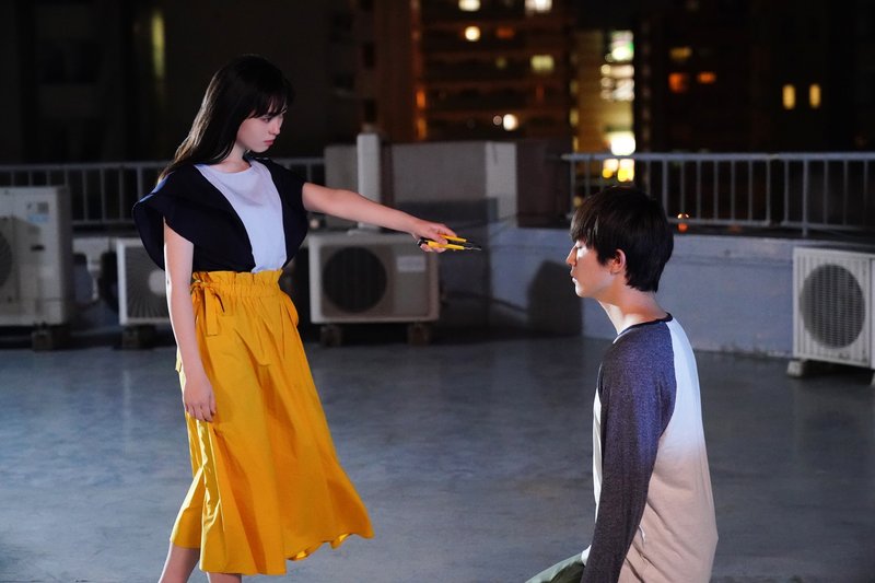 屋上で宮市莉央(福原遥)が黒須越郎(杉野遥亮)にカッターを向ける場面(映画「羊とオオカミの恋と殺人」場面写真)