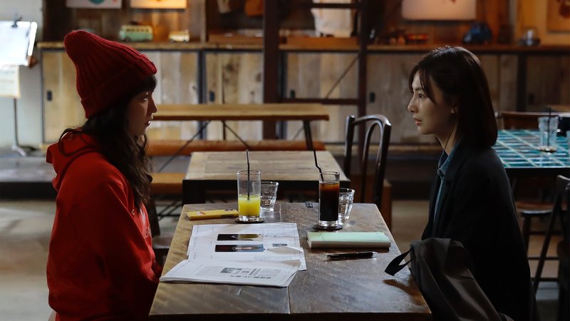 カフェのテーブルで向かい合う2人の女性(連続ドラマW「落日」第1話の場面)